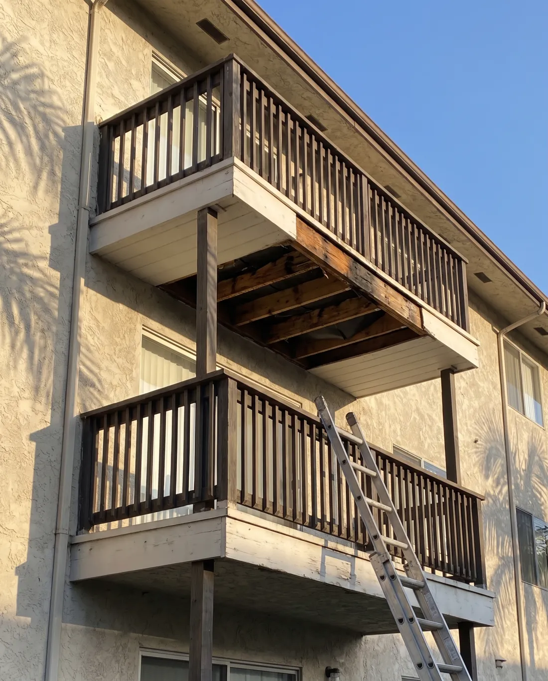 Elevated balcony inspection opening on a stucco apartment building